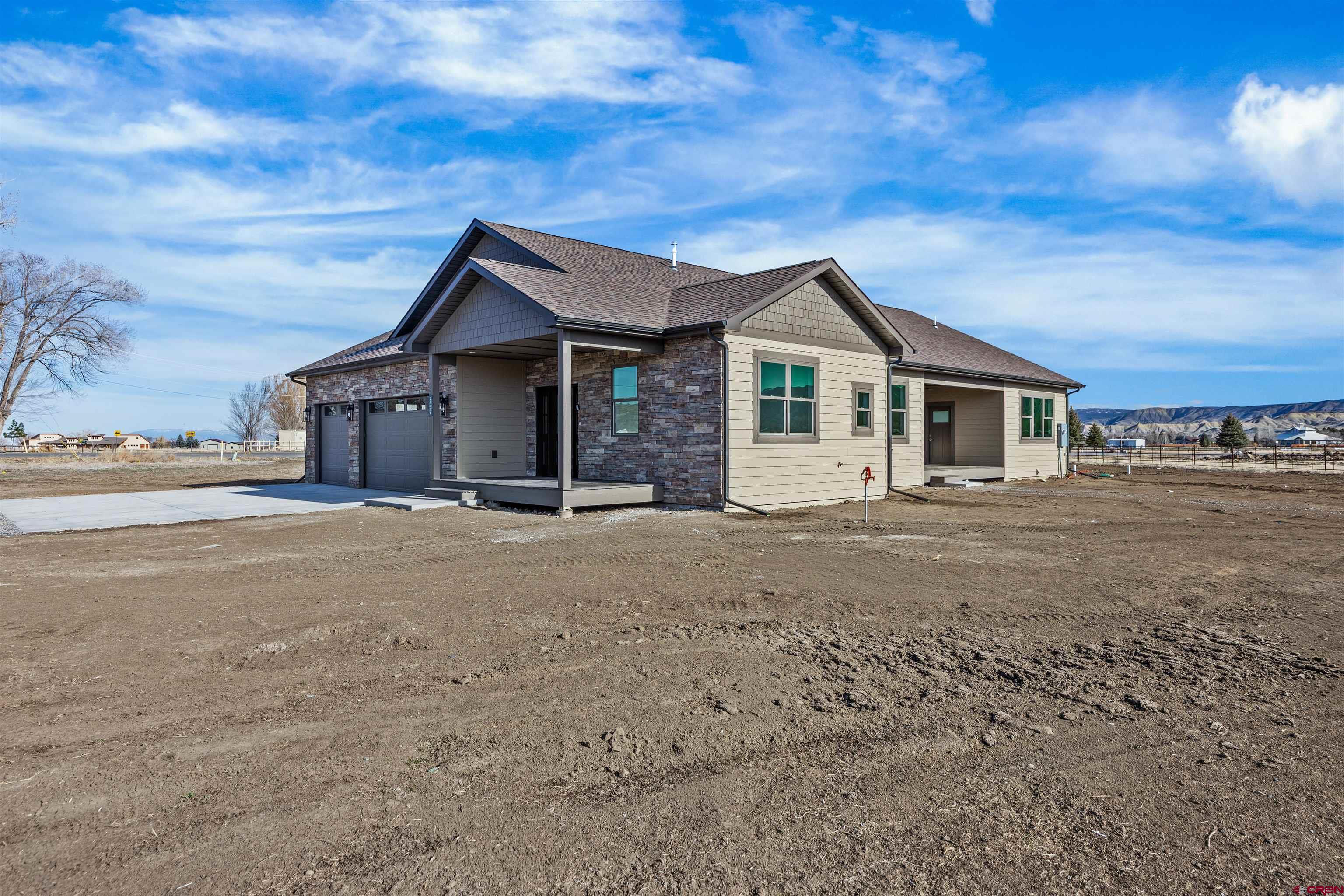 21470 Government Springs Road Montrose, CO 81403 - Photo 6 of 42 a front view of a house with a garden