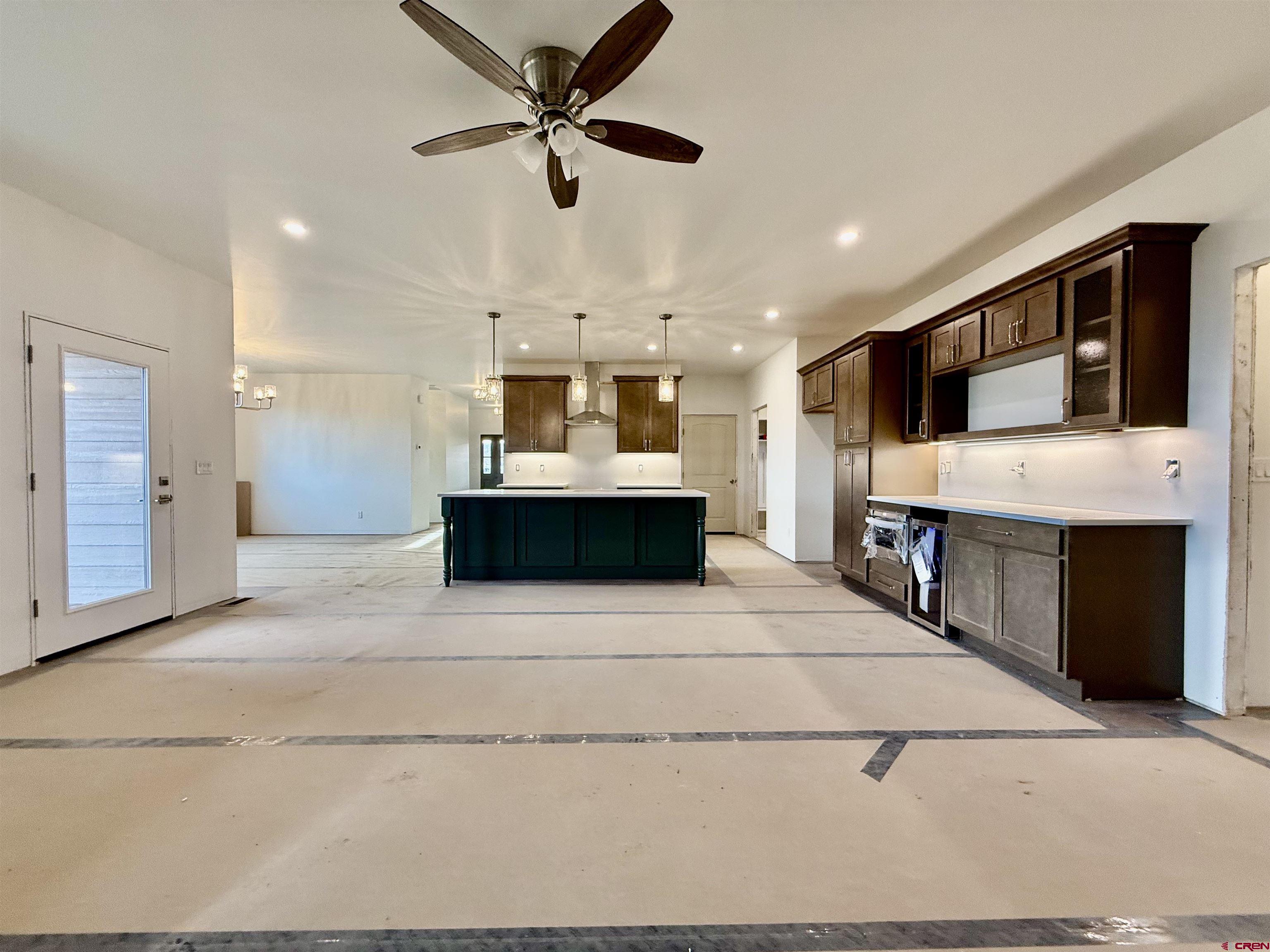 21470 Government Springs Road Montrose, CO 81403 - Photo 24 of 25 a view of living room kitchen with stainless steel appliances kitchen island a flat screen tv a island and a ceiling fan