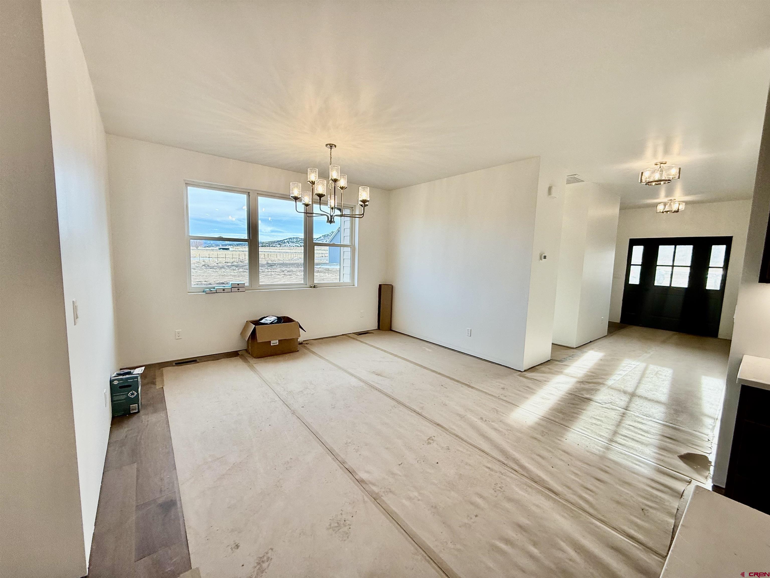 21470 Government Springs Road Montrose, CO 81403 - Photo 8 of 25 en empty room with windows and chandelier