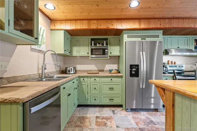 a kitchen with stainless steel appliances granite countertop a refrigerator and a stove