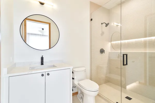 a bathroom with a toilet sink vanity and mirror