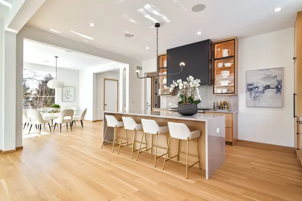 a dining room with wooden floor a glass table and chairs