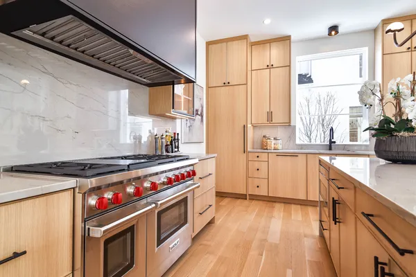 a kitchen with a stove a sink and wooden floor