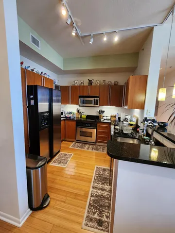 a kitchen with stainless steel appliances granite countertop a refrigerator stove and sink