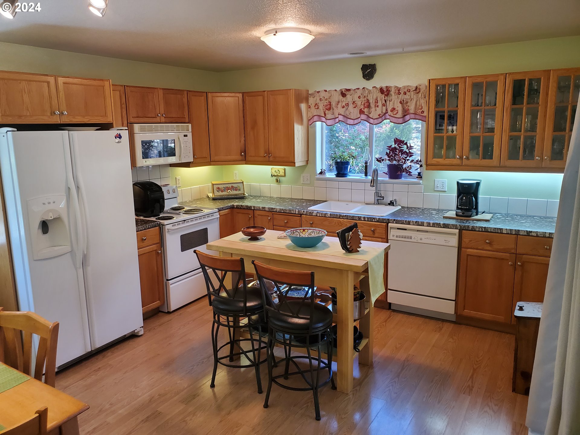 952 South 67th Street Springfield, OR 97478 - Photo 21 of 44 a kitchen with a table chairs refrigerator and microwave