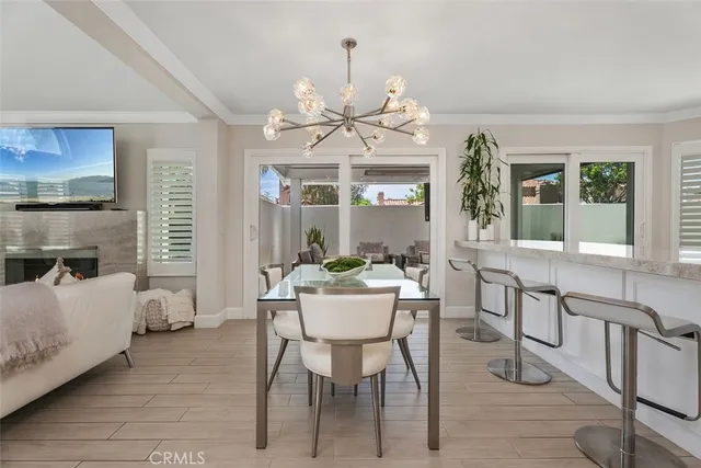 a dining room with furniture a chandelier and wooden floor