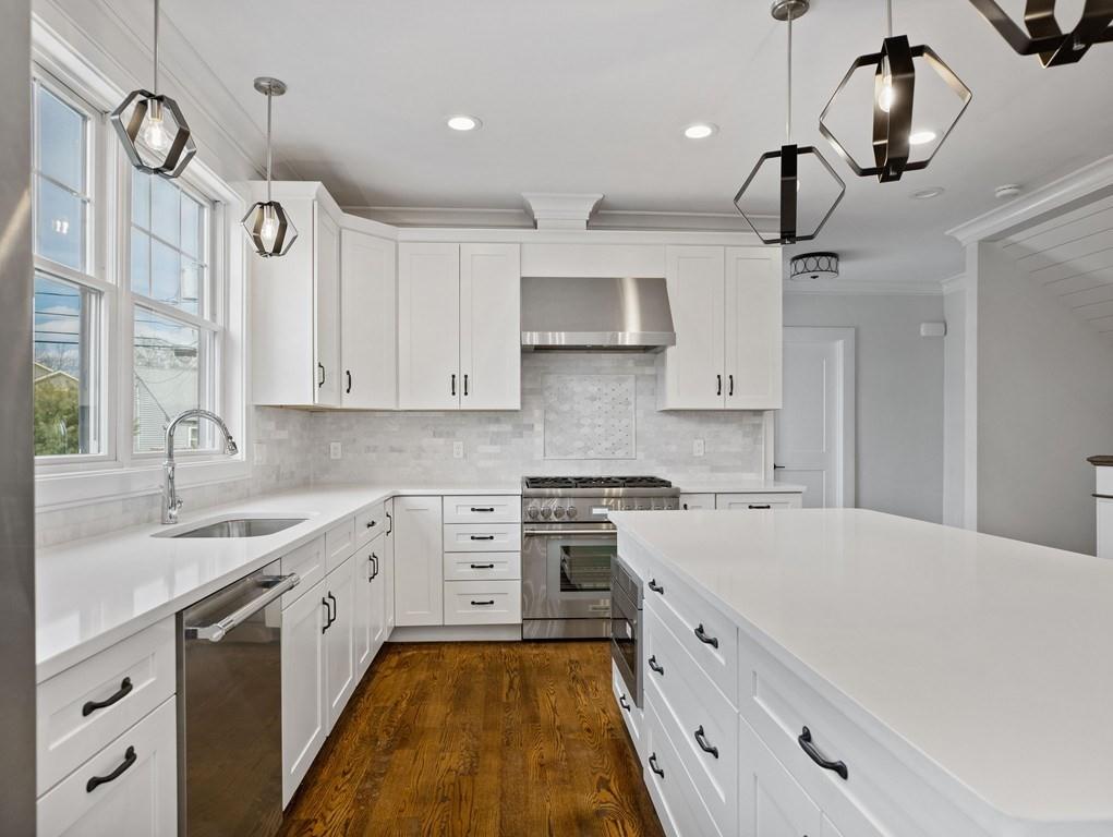 a large kitchen with stainless steel appliances granite countertop a sink and cabinets