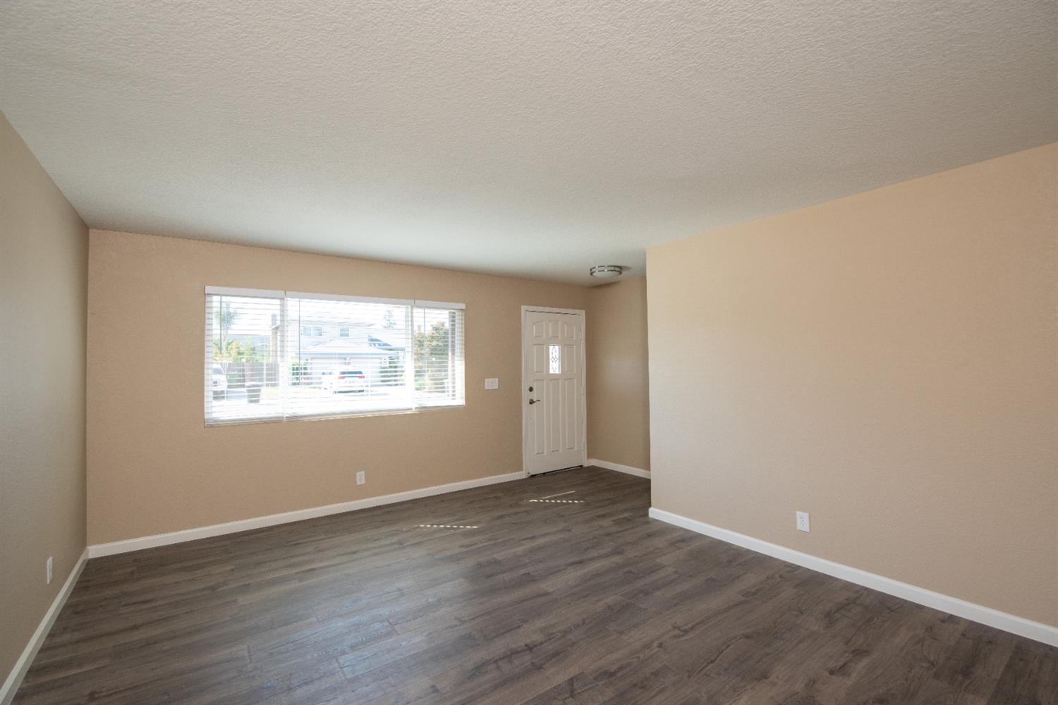 1621 Davis Street Ripon, CA 95366 - Photo 11 of 43 an empty room with wooden floor and windows