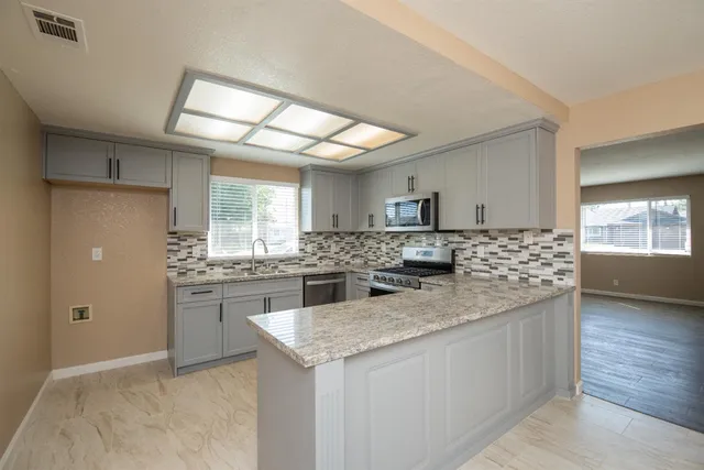 a kitchen with stainless steel appliances granite countertop a sink and cabinets