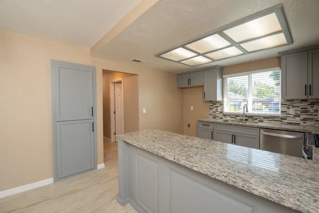 a kitchen with stainless steel appliances granite countertop a sink stove and refrigerator
