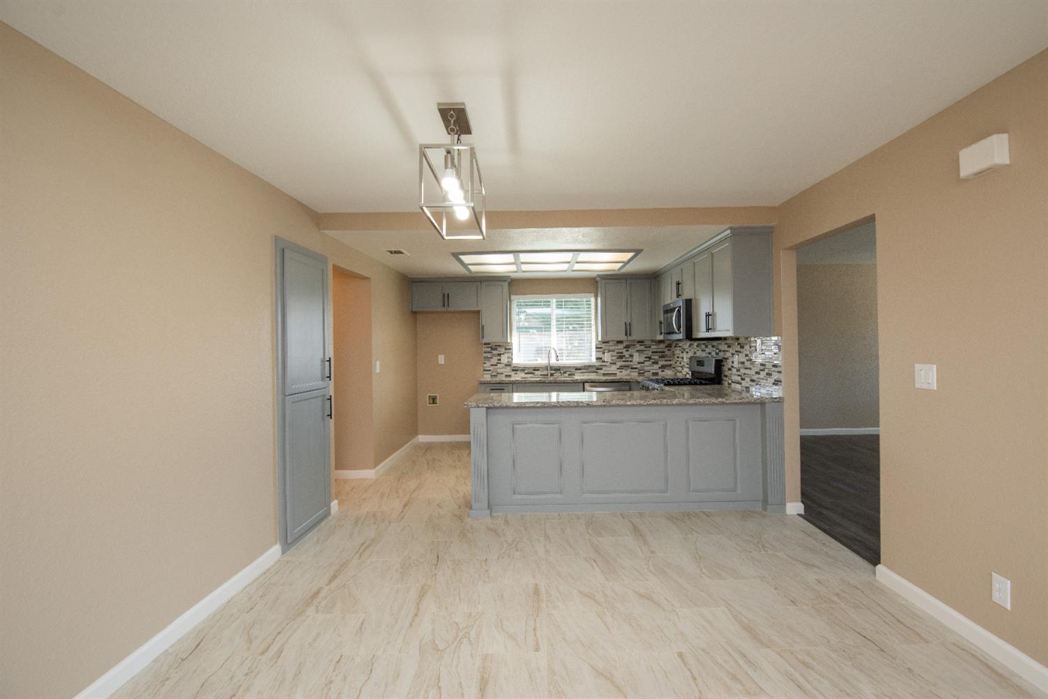1621 Davis Street Ripon, CA 95366 - Photo 19 of 43 a large kitchen with a wooden floor and white cabinets