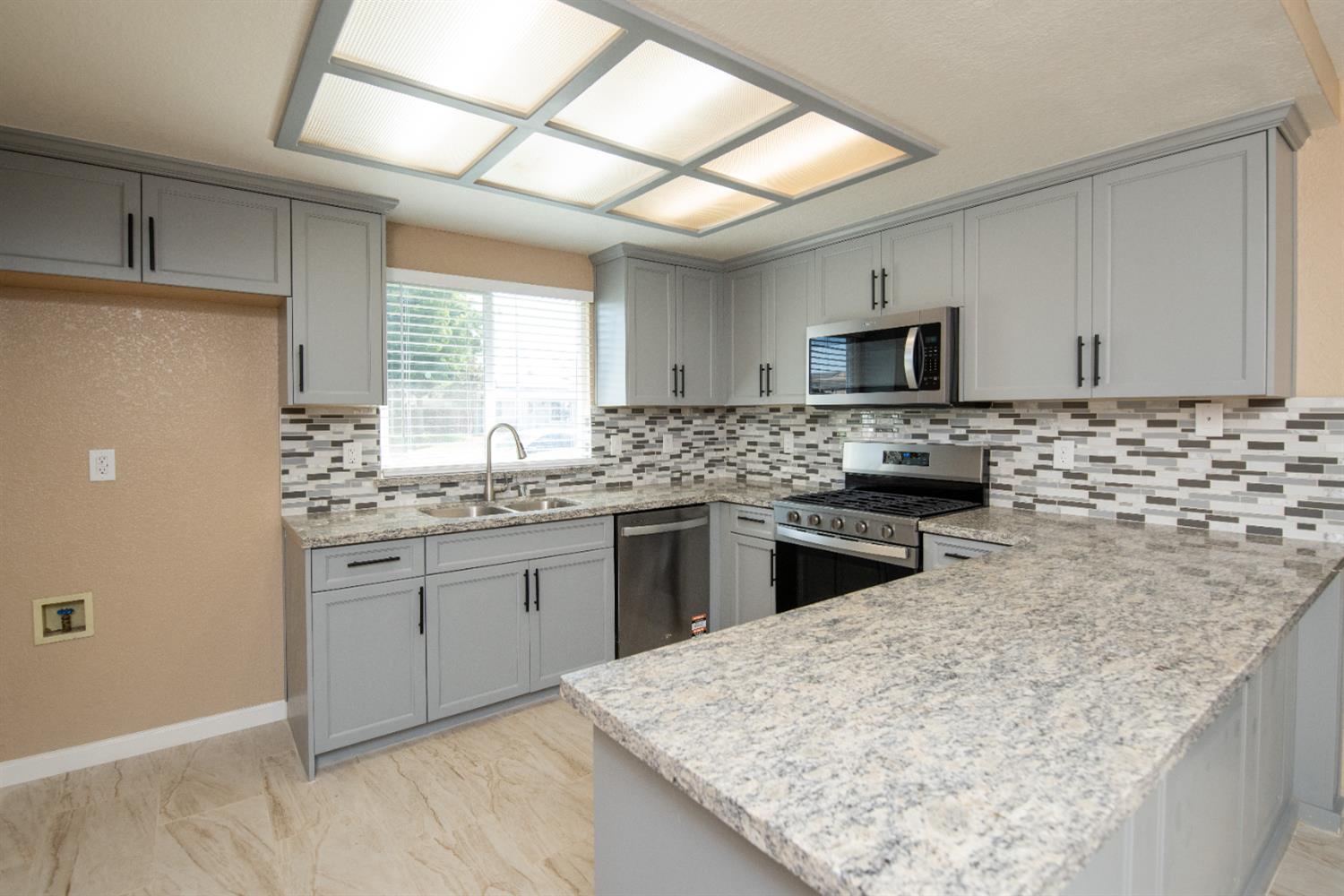 1621 Davis Street Ripon, CA 95366 - Photo 5 of 43 a kitchen with stainless steel appliances granite countertop a sink stove and refrigerator