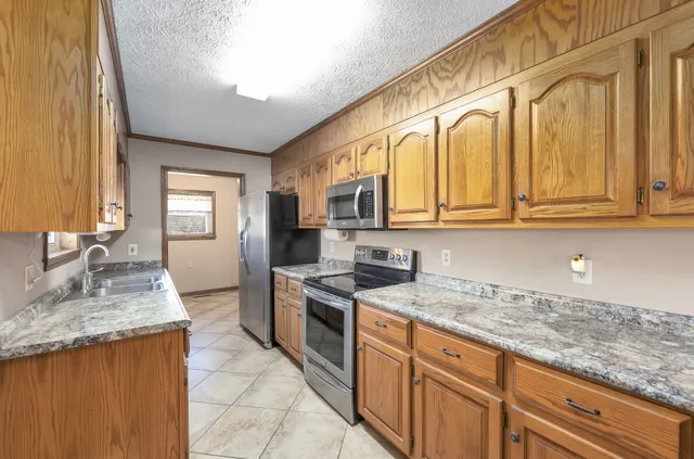a kitchen with stainless steel appliances granite countertop a sink stove and cabinets