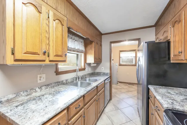 a kitchen with a granite countertop sink and cabinets