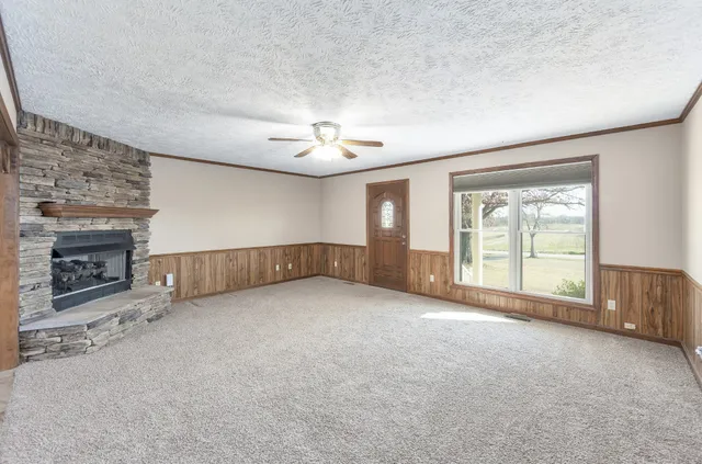 an empty room with windows and fireplace