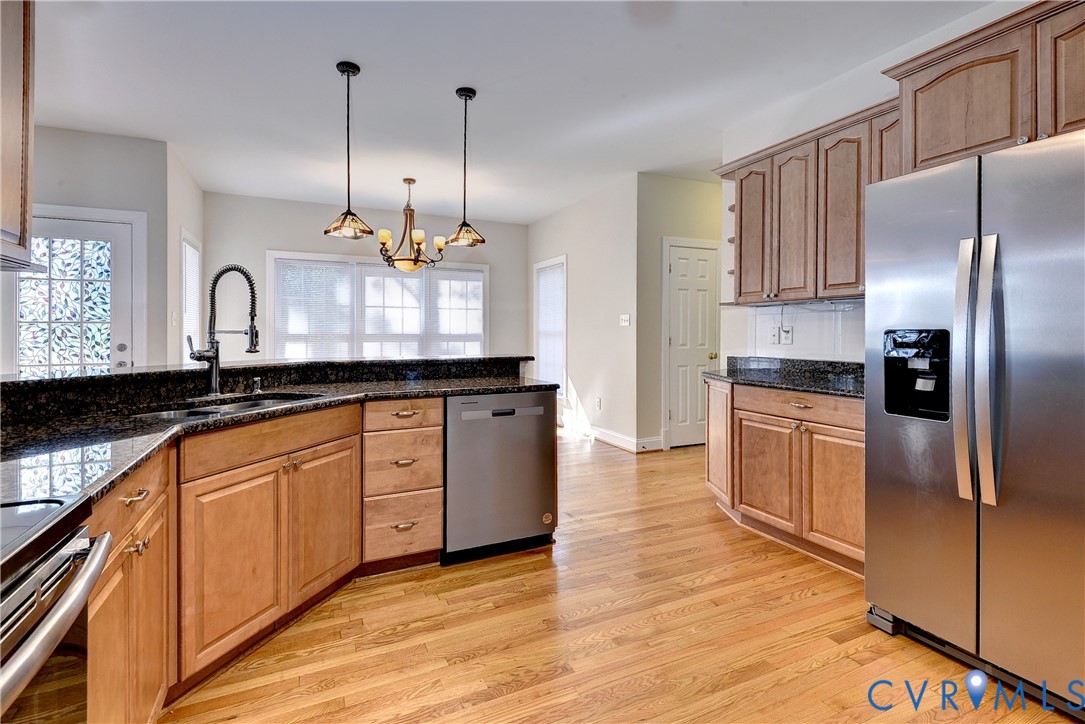 11385 Winding River Road Providence Forge, VA 23140 - Photo 17 of 43 a kitchen with stainless steel appliances granite countertop a sink a stove a refrigerator and island with wooden floor