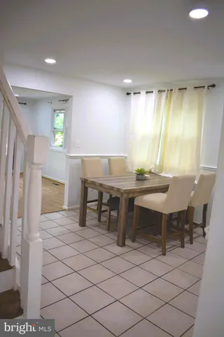 a living room with stainless steel appliances kitchen island granite countertop a refrigerator and cabinets