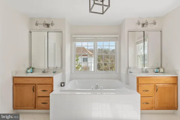 a bathroom with a tub sink and mirror