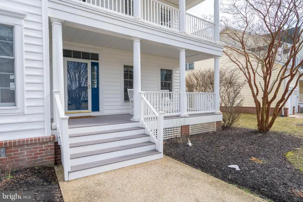 a view of a house with a bench in a backyard