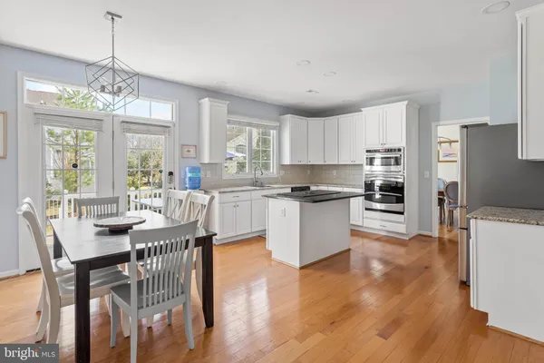 a open dining room with stainless steel appliances kitchen island granite countertop furniture and a view of kitchen