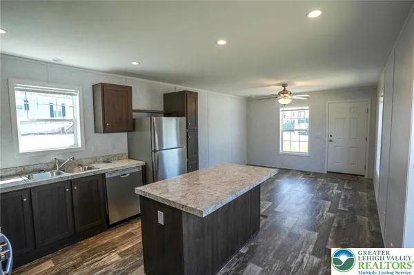 a kitchen with a sink a refrigerator and wooden cabinets