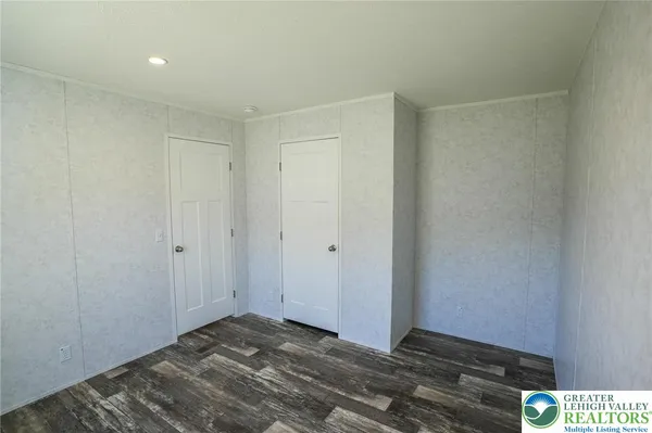 a view of hallway with closet and wooden floor
