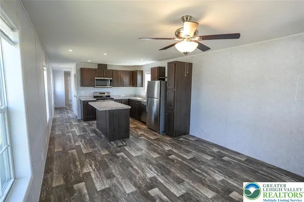 a kitchen with stainless steel appliances a refrigerator and a chandelier