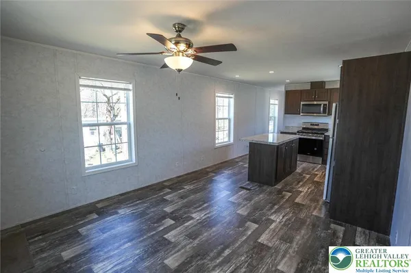 a living room with stainless steel appliances kitchen island granite countertop furniture and a window