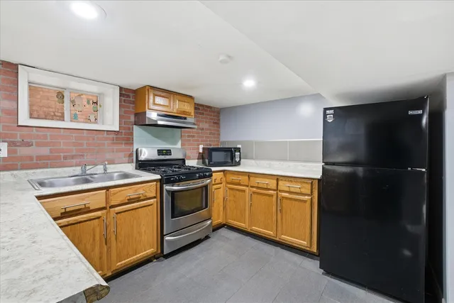 a kitchen with stainless steel appliances granite countertop a refrigerator and a stove top oven