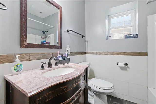 a bathroom with a sink a toilet and a mirror