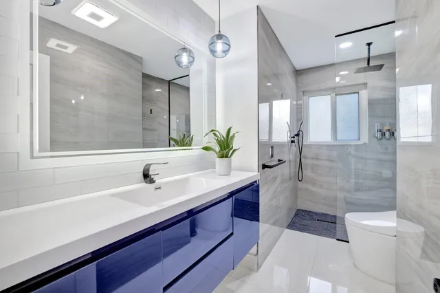 a bathroom with a sink a toilet and shower