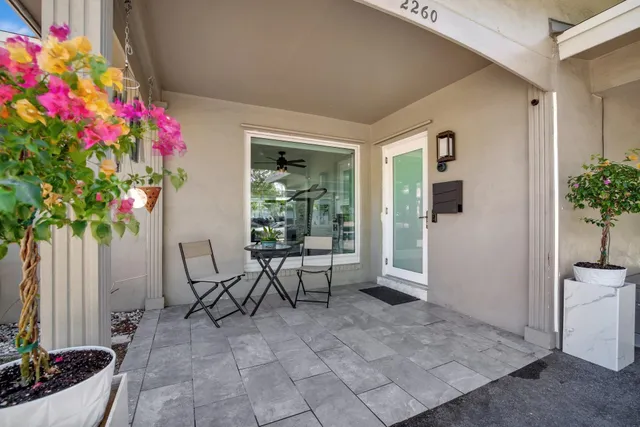 a view of a porch with chairs and potted plants