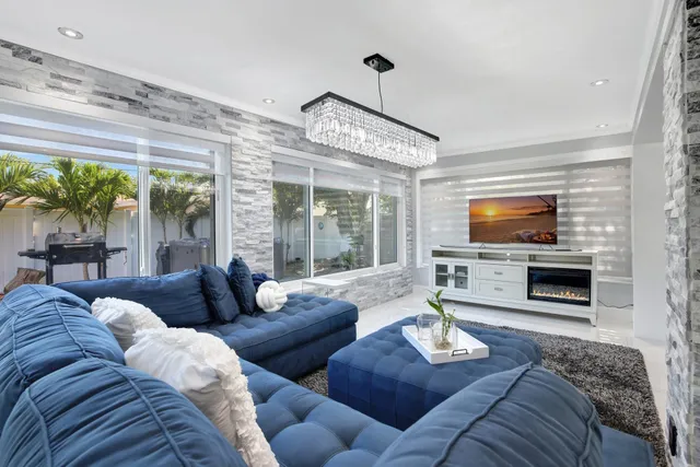 a living room with furniture flat screen tv and a large window