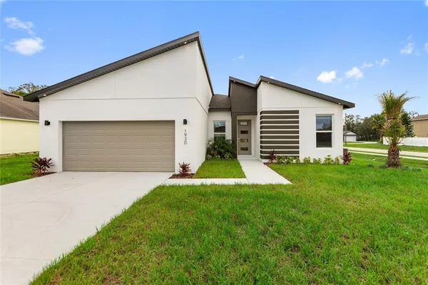 a view of a house with a yard and garage