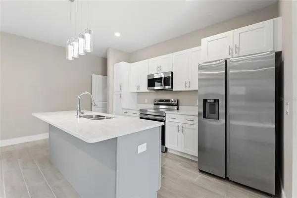 a kitchen with kitchen island stainless steel appliances a sink and cabinets