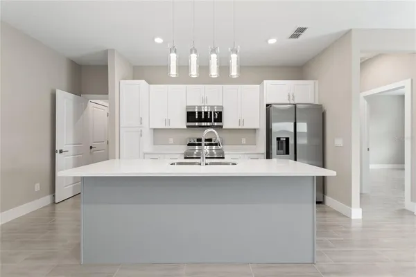 a kitchen with stainless steel appliances a stove refrigerator sink and microwave