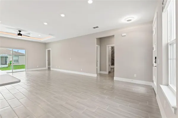 a view of a livingroom with a kitchen island stainless steel appliances refrigerator stove and wooden floor