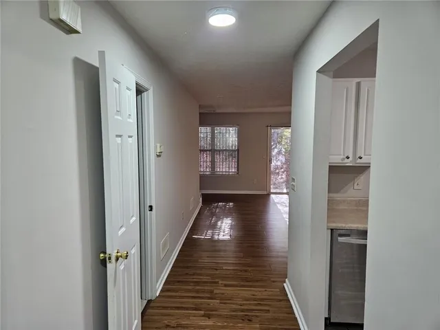 a view of a hallway with wooden floor and staircase