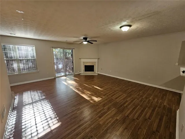 an empty room with windows and fireplace