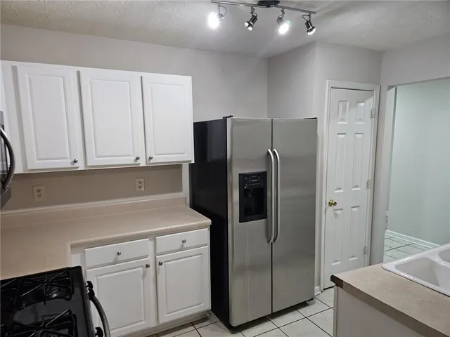 a kitchen with stainless steel appliances white cabinets and a refrigerator