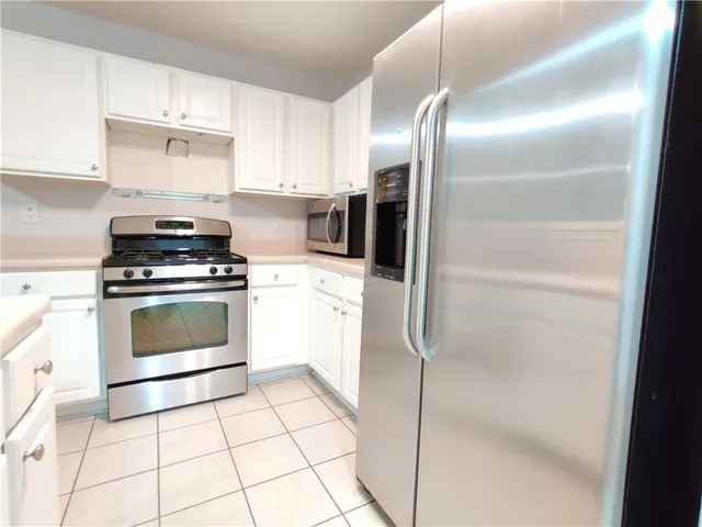 a kitchen with cabinets and steel stainless steel appliances