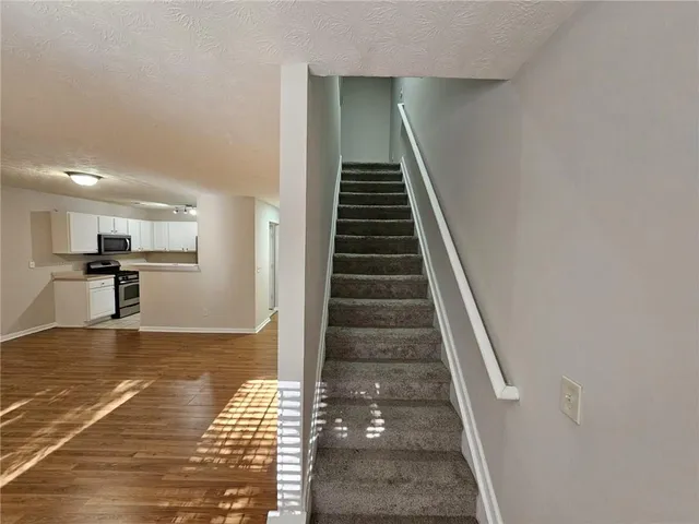 a view of kitchen with wooden floor and stairs