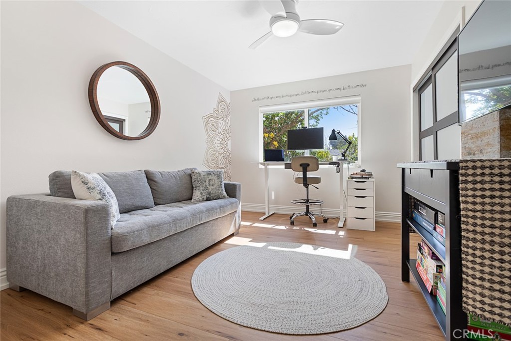 5555 Fairview Place Agoura Hills, CA 91301 - Photo 23 of 39 a living room with furniture a mirror and a flat screen tv