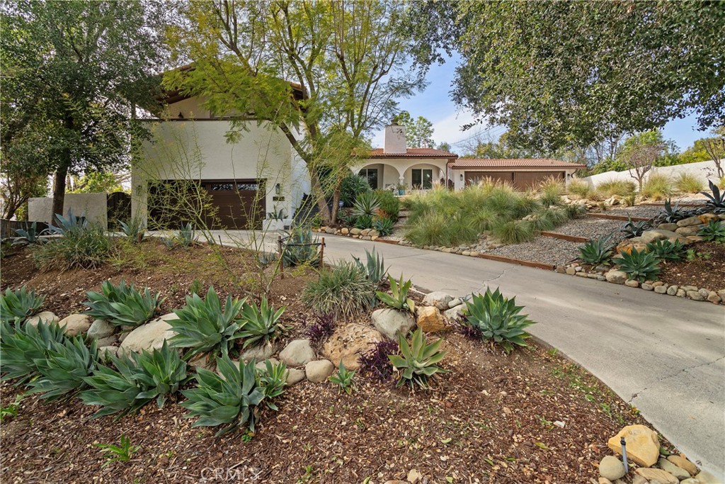 5555 Fairview Place Agoura Hills, CA 91301 - Photo 3 of 39 a front view of a house with a yard and a garden