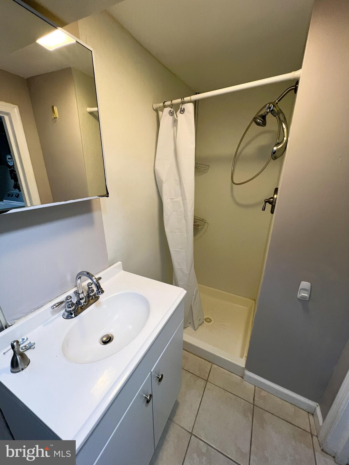3705 Bancroft Road Baltimore, MD 21215 - Photo 33 of 50 a bathroom with a sink a mirror and shower