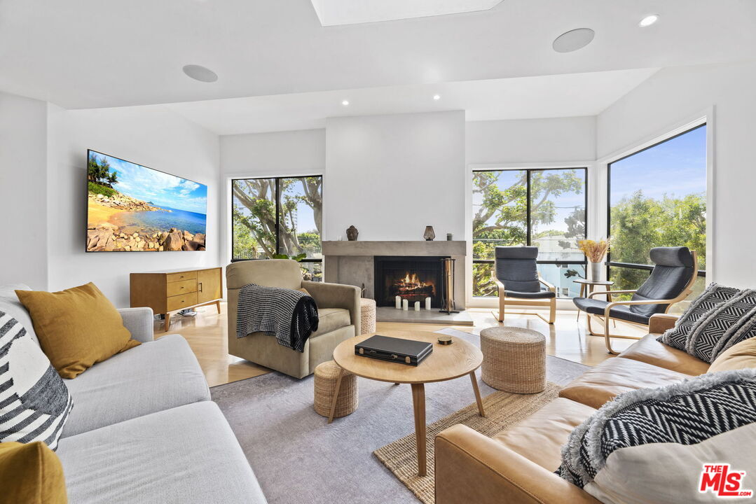 a living room with furniture a fireplace and a large window