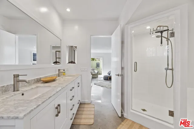 a spacious bathroom with a granite countertop sink mirror and shower