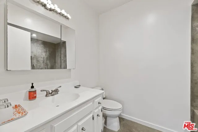 a bathroom with a sink a toilet and mirror