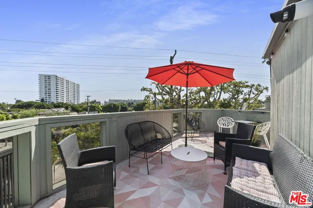 a view of a chair and tables in the balcony
