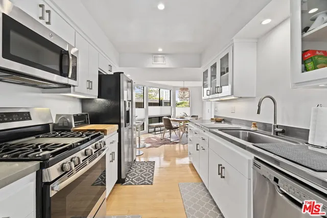 a kitchen with stainless steel appliances a sink dishwasher stove top oven and refrigerator